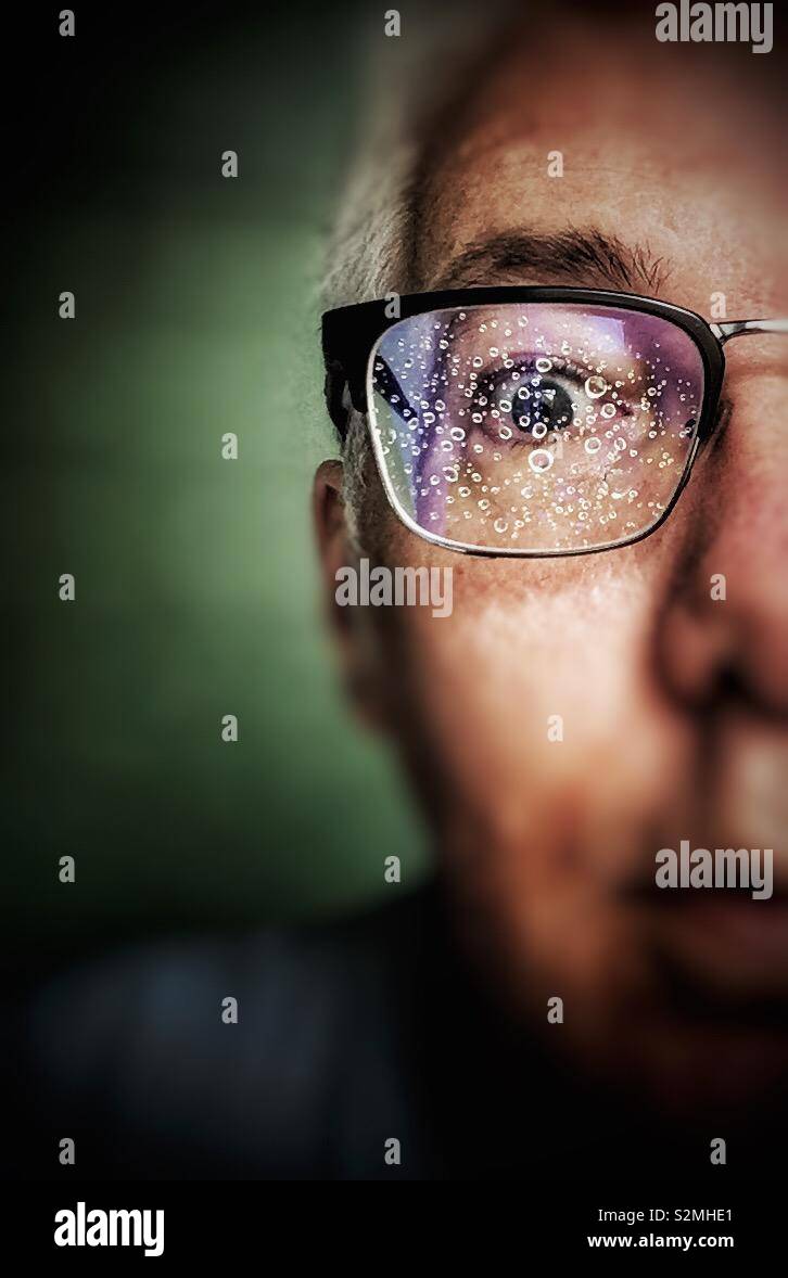Les gouttelettes d'eau sur une lentille d'une paire de lunettes Banque D'Images