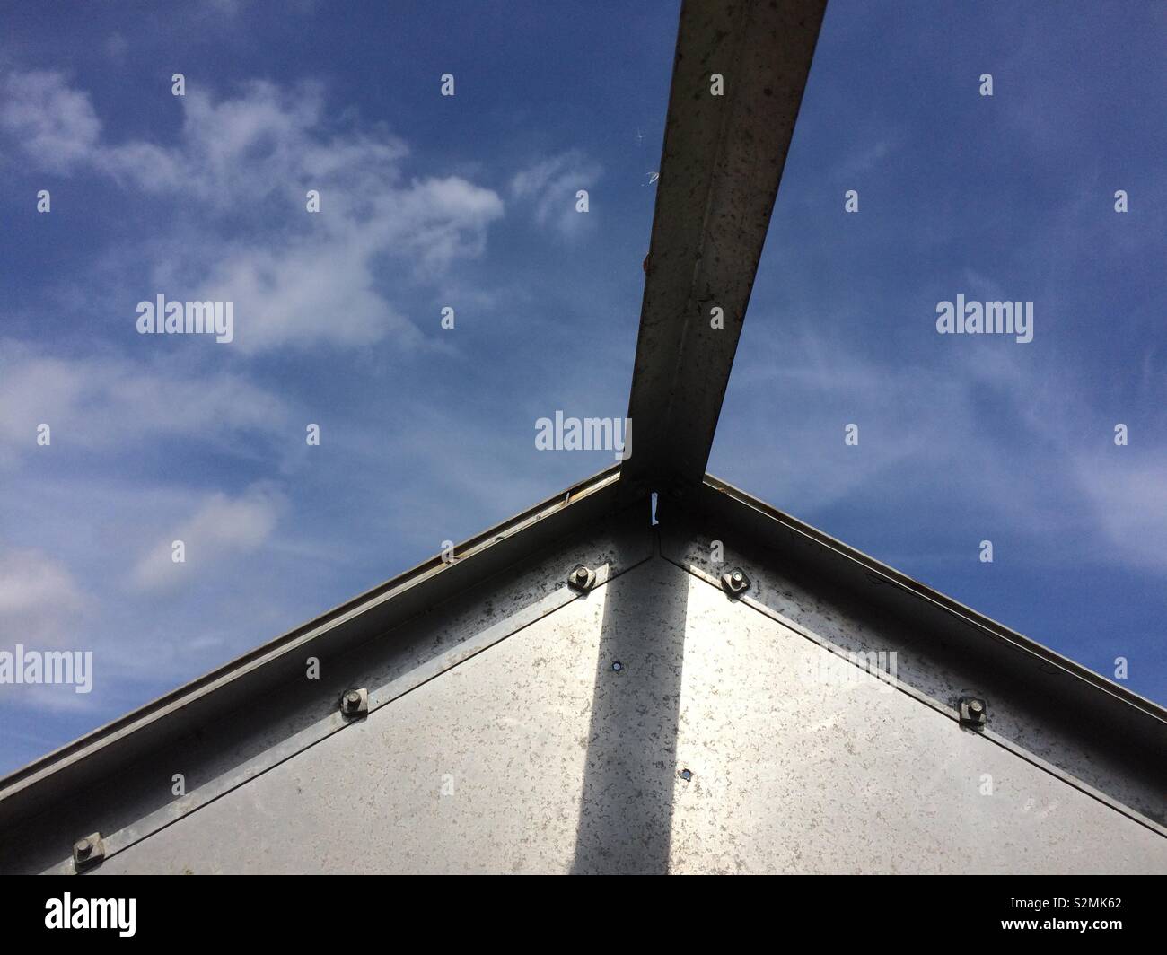 Détail de structure métallique de green house et vue de ciel bleu et nuages Banque D'Images