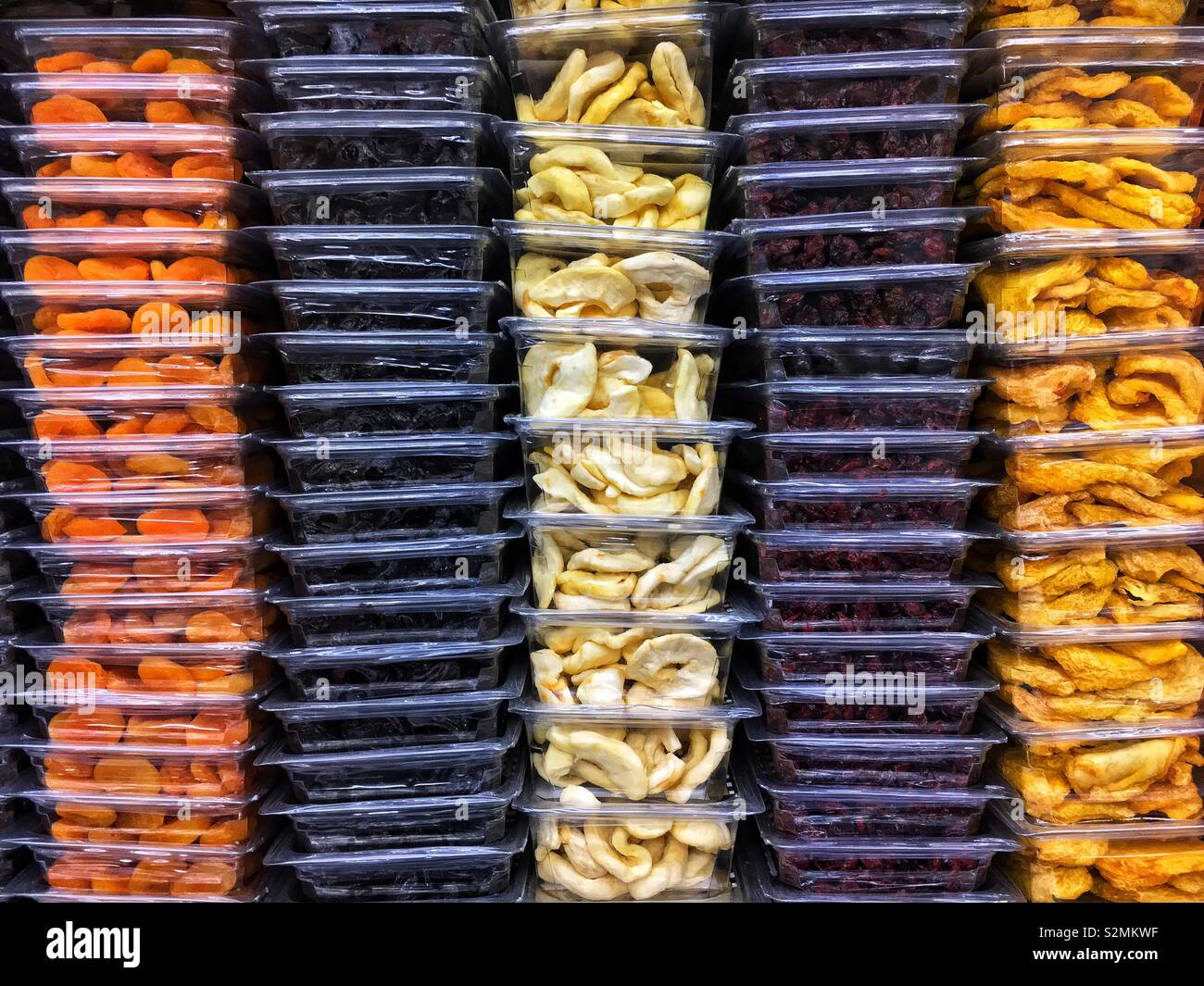 Les contenants en plastique empilés plein de pruneaux, abricots secs, pommes séchées, canneberges séchées et d'autres sur l'affichage et à la vente à la marché du terroir. Banque D'Images