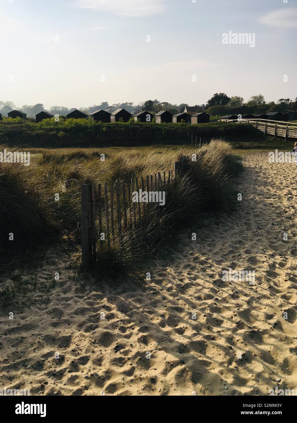 Dunes de sable avec des cabines de plage dans le soleil du soir Banque D'Images