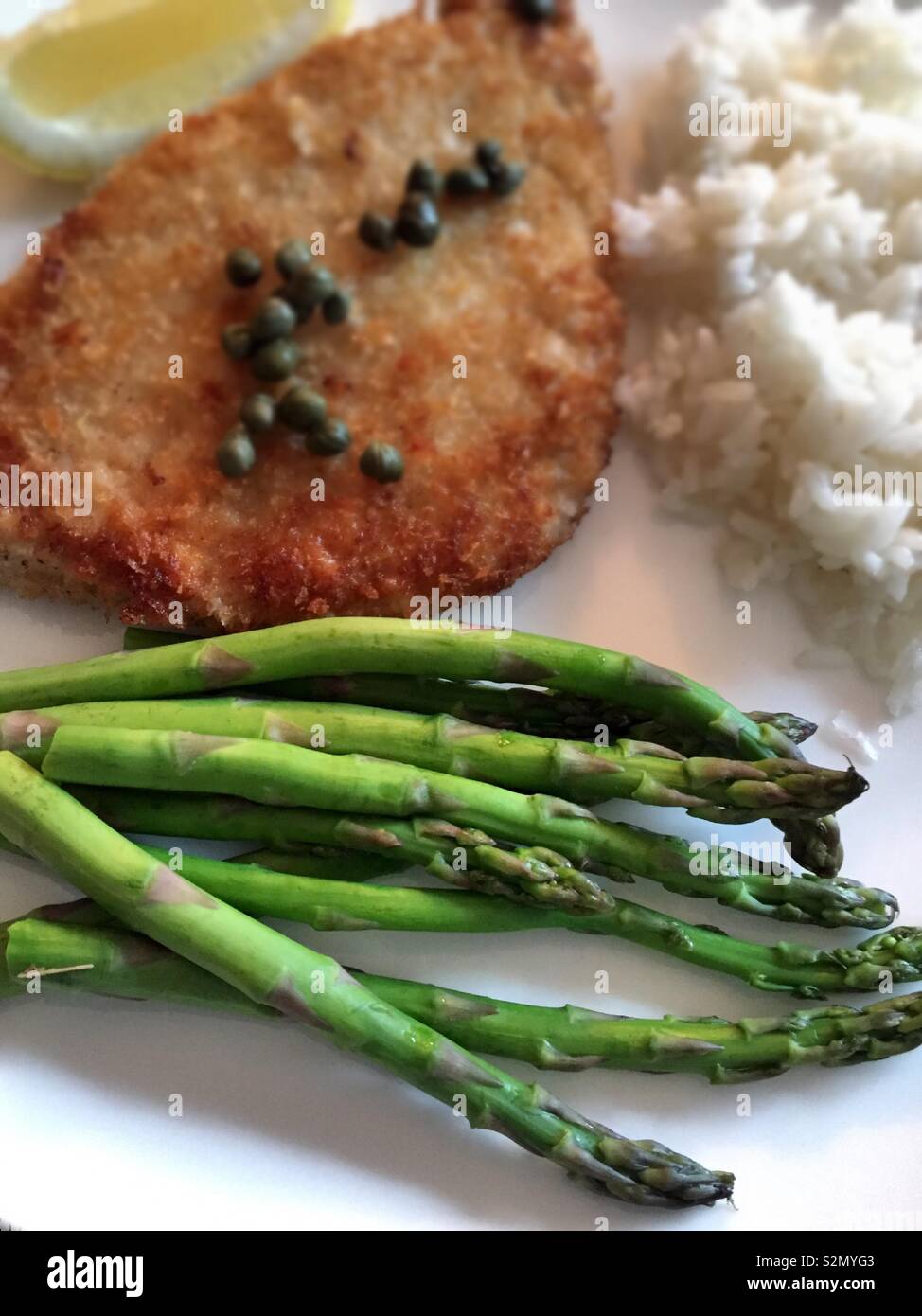 Repas gastronomique de Wiener Schnitzel et câpres avec asperges fraîches et le riz. - Image de stock capturée avec un smartphone