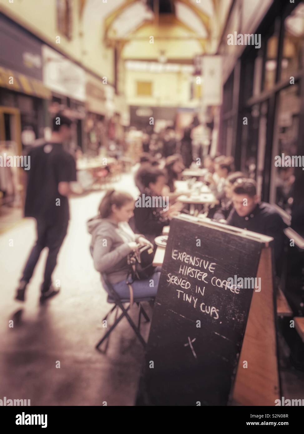 "Cher hipster café servi dans de petites tasses" écrit sur une affiche à l'extérieur d'un café dans le village de Brixton, Londres, Angleterre. Banque D'Images