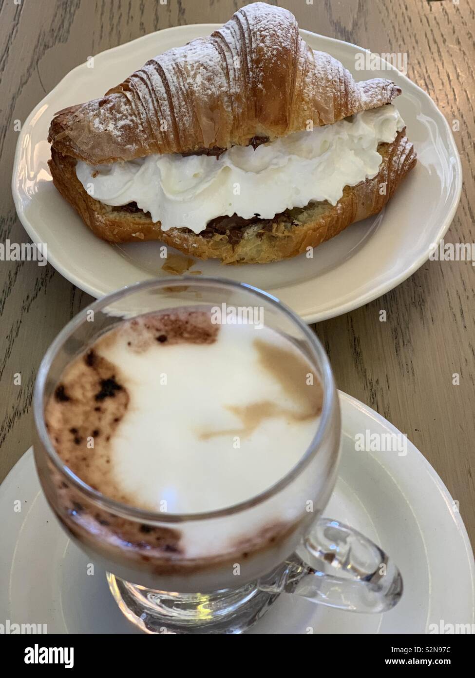 Un délicieux cappuccino et un croissant au chocolat et crème Banque D'Images