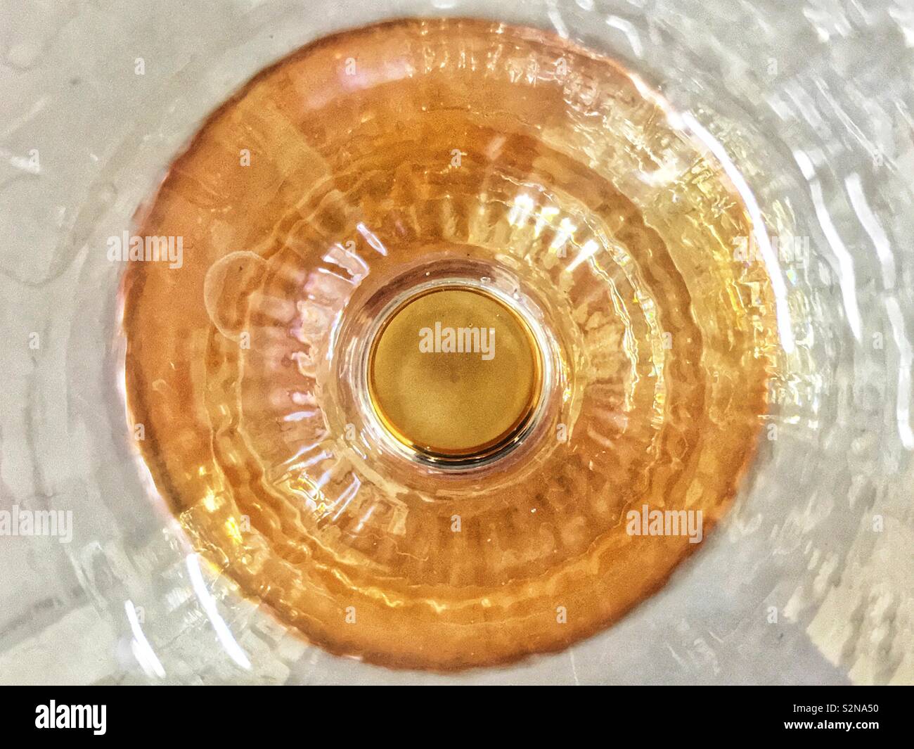 Châssis complet du fond d'une tasse en verre clair et or. Banque D'Images