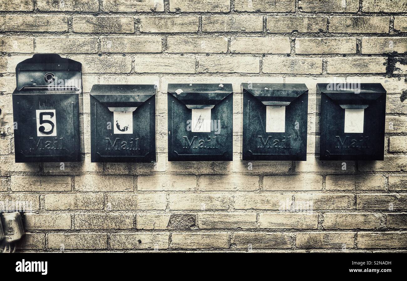 Black metal boîtes aux lettres sur un mur de briques Banque D'Images