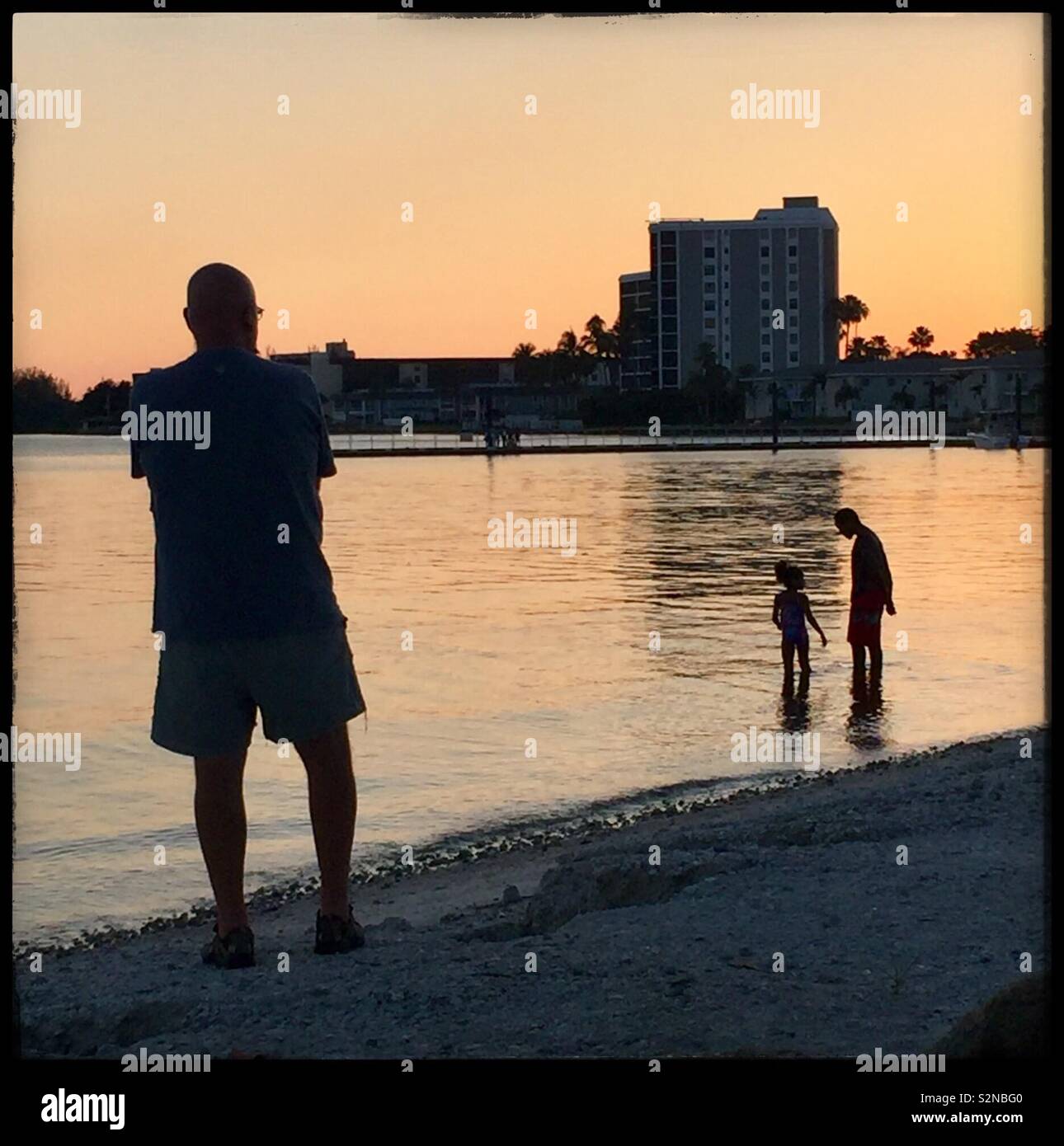L'homme domine les membres de la famille au bord de l'eau, USA 2019 Katharine Andriotis Banque D'Images