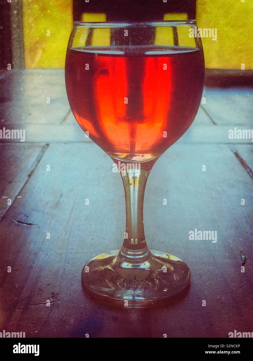 Verre de vin rouge dans une table en bois avec fenêtre light Banque D'Images