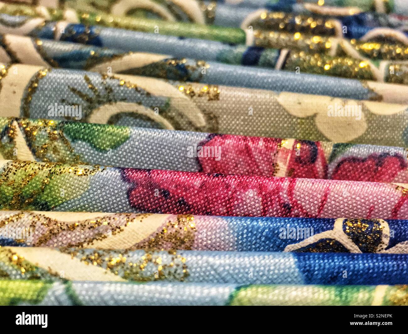 Tissu plié avec gold glitter sparkles et et une rose, blanc et bleu motif. Banque D'Images