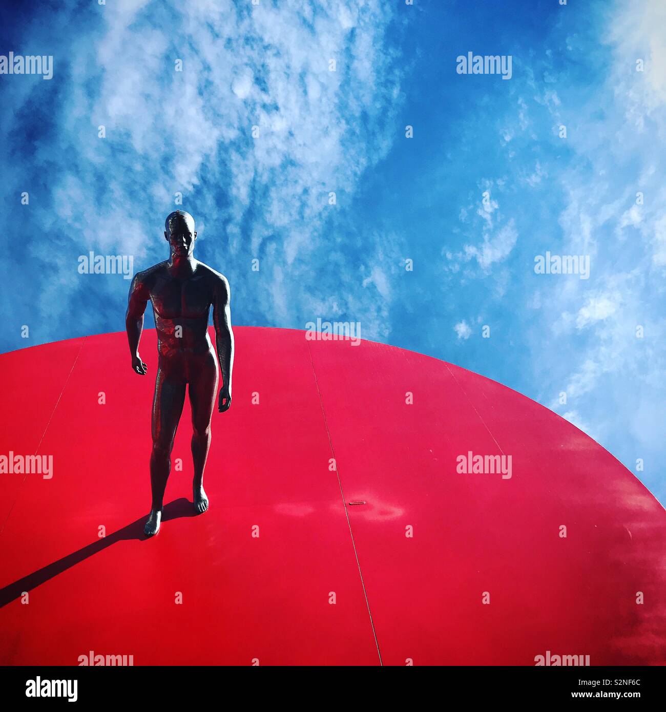 Une sculpture d'un homme marchant sur un espace rouge décore un monument d'un cœur rouge à Fatima, Portugal Banque D'Images