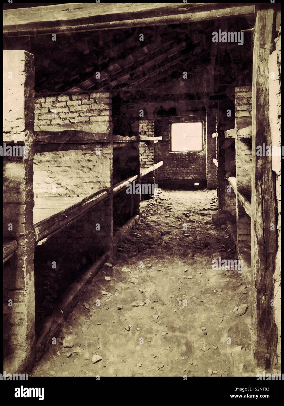 Un effet rétro à la photo d'un des survivants de l'abris à le nazi d'Auschwitz II-Birkenau Camp de concentration. Cette structure a été probablement utilisé par les femmes juives - inhumainement entassés dans ces dortoirs. © CH. Banque D'Images