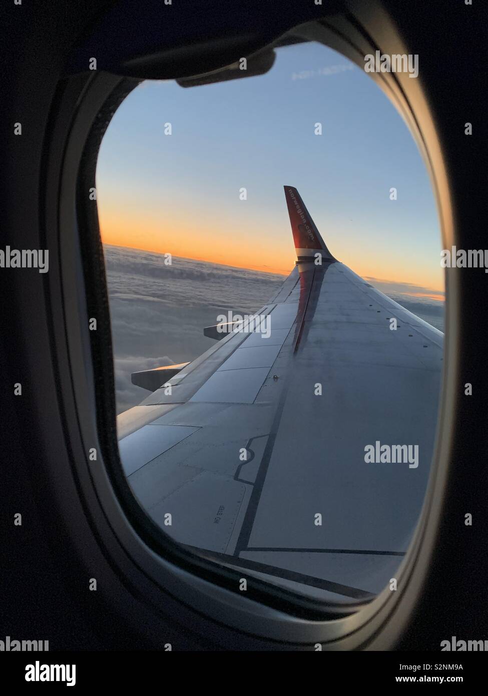 Sur le coucher du soleil au-dessus des nuages à partir de la fenêtre de l'avion Banque D'Images