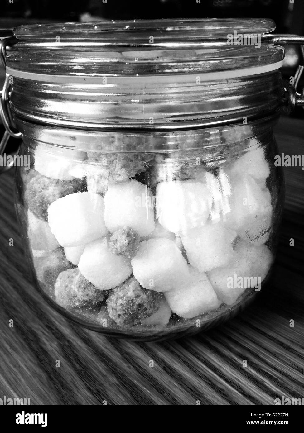 Photographie en noir et blanc des morceaux de sucre dans un pot Banque D'Images