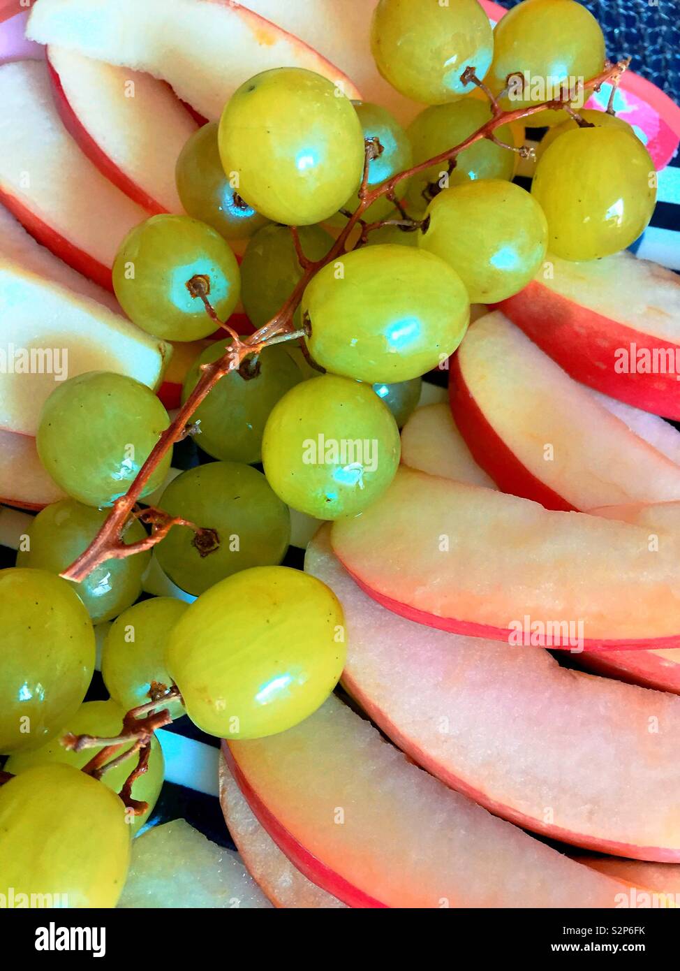 Close up télévision jeter d'un plat de raisins et les pommes en tranches. - Image de stock capturée avec un smartphone