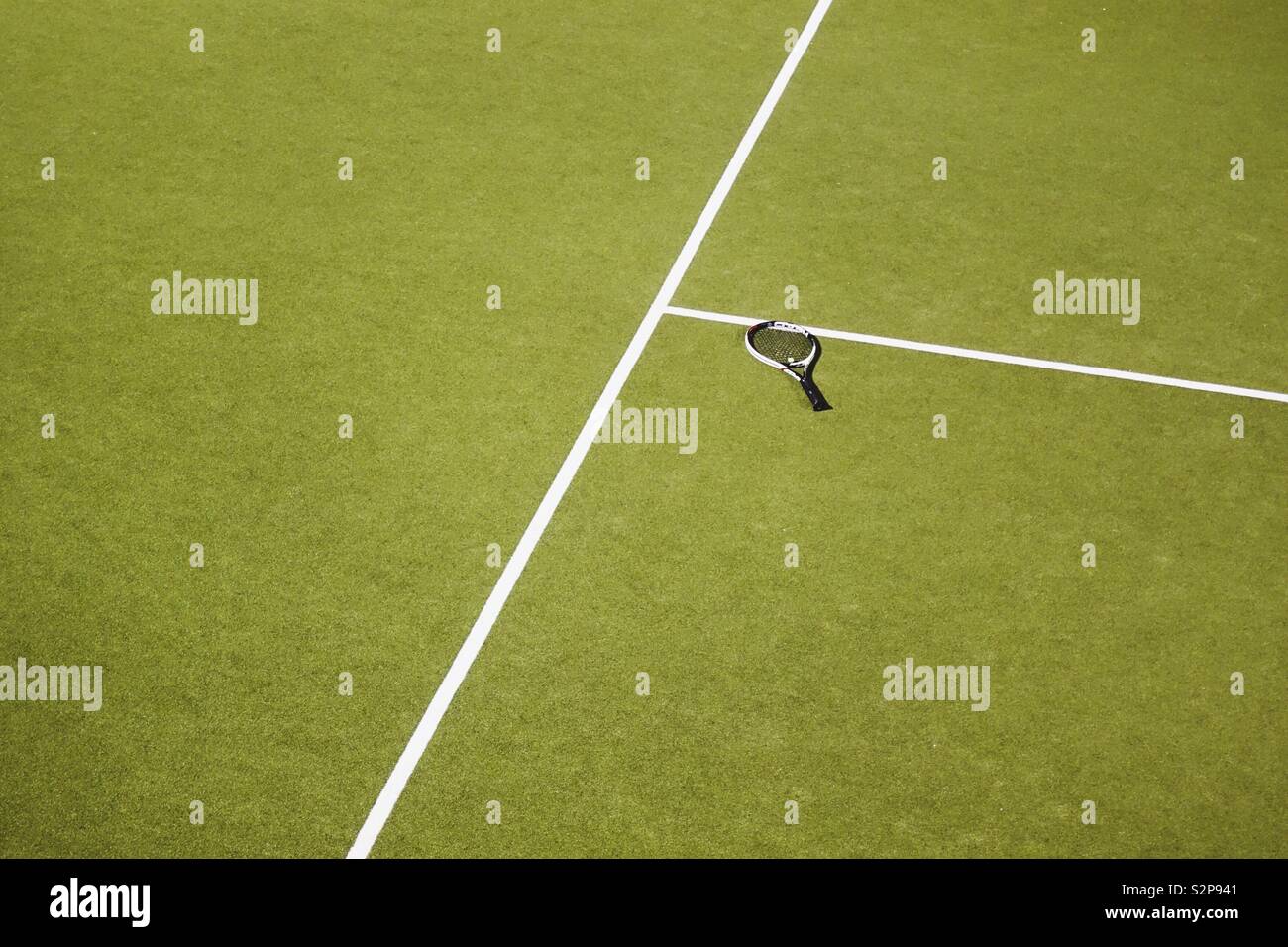 Raquette de tennis simple oubli de pose sur le sol au milieu de la matchfield Banque D'Images