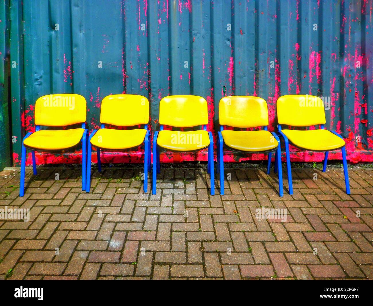 5 chaises jaune dans une rangée Banque D'Images