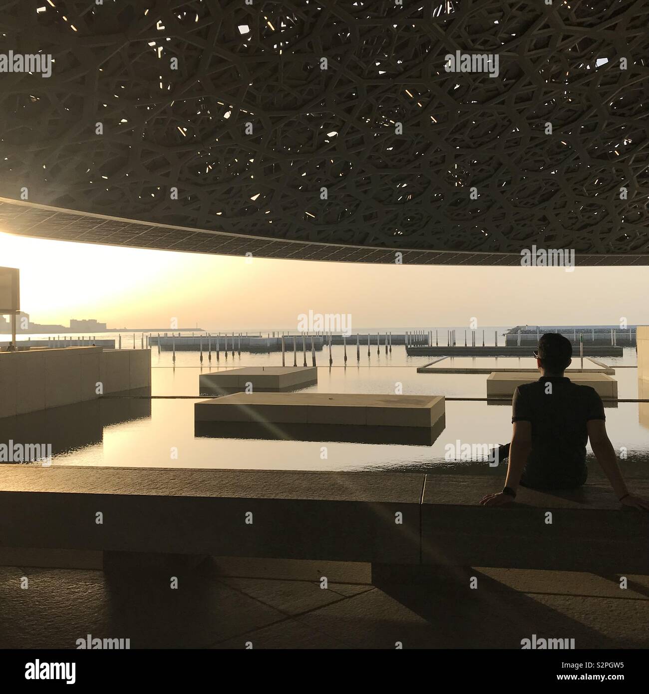 Musée du Louvre Abu Dhabi, en admirant le coucher du soleil au bord de la coupole moderne design. Banque D'Images