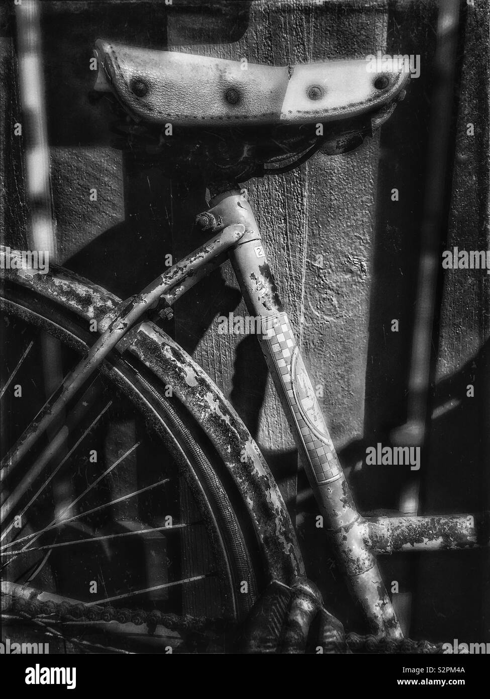 Vieux vélo contre une clôture en noir et blanc Banque D'Images