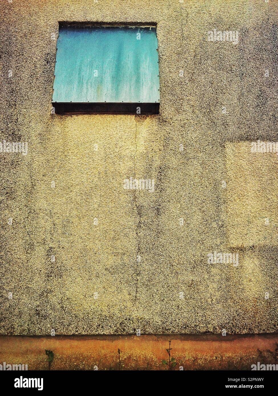 Mur de crépi d'un ancien bâtiment industriel métallique avec système de ventilation. Banque D'Images