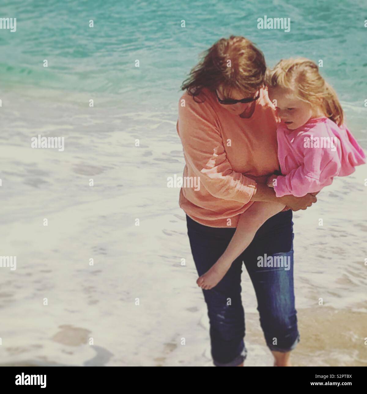 Grand-mère et petite-fille tremper les orteils dans la mer Banque D'Images