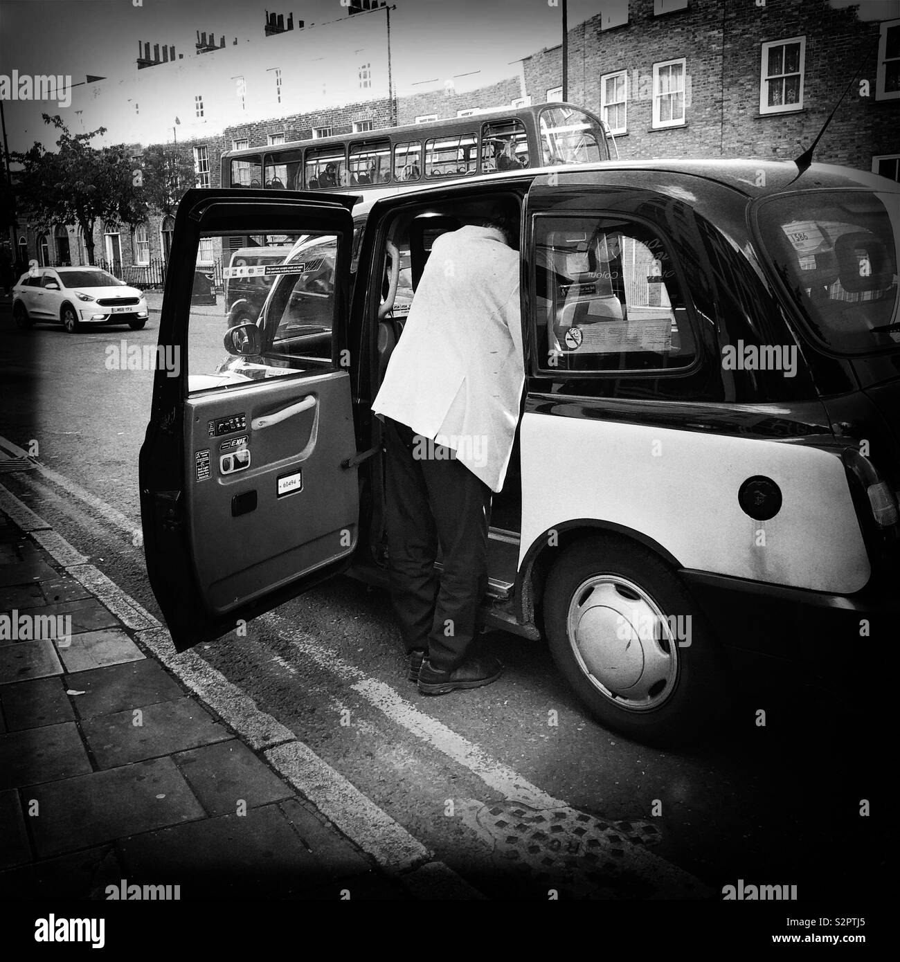 Homme avec une veste blanche en prenant un taxi noir de Londres Banque D'Images