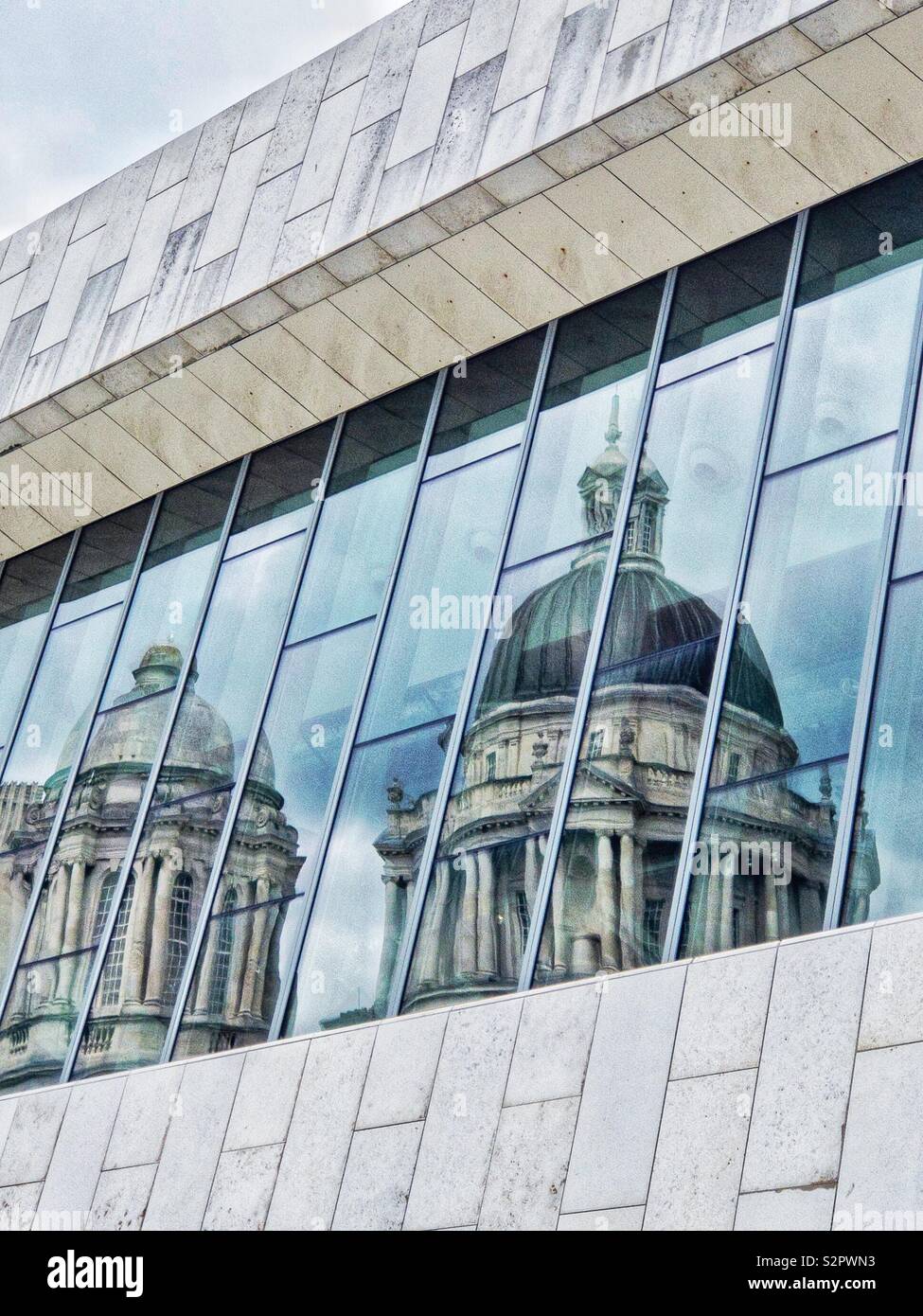 Réflexion de vieux bâtiments à coupole dans les fenêtres d'un immeuble moderne à Liverpool (Royaume-Uni). Banque D'Images