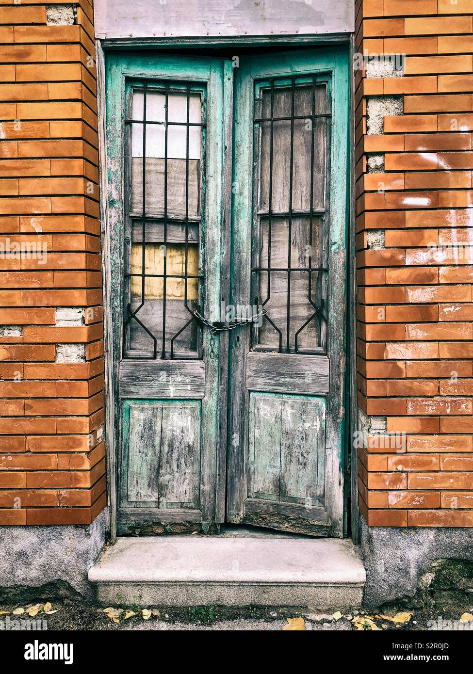 Vieille porte en bois avec chaîne et cadenas, bâtiment abandonné Banque D'Images