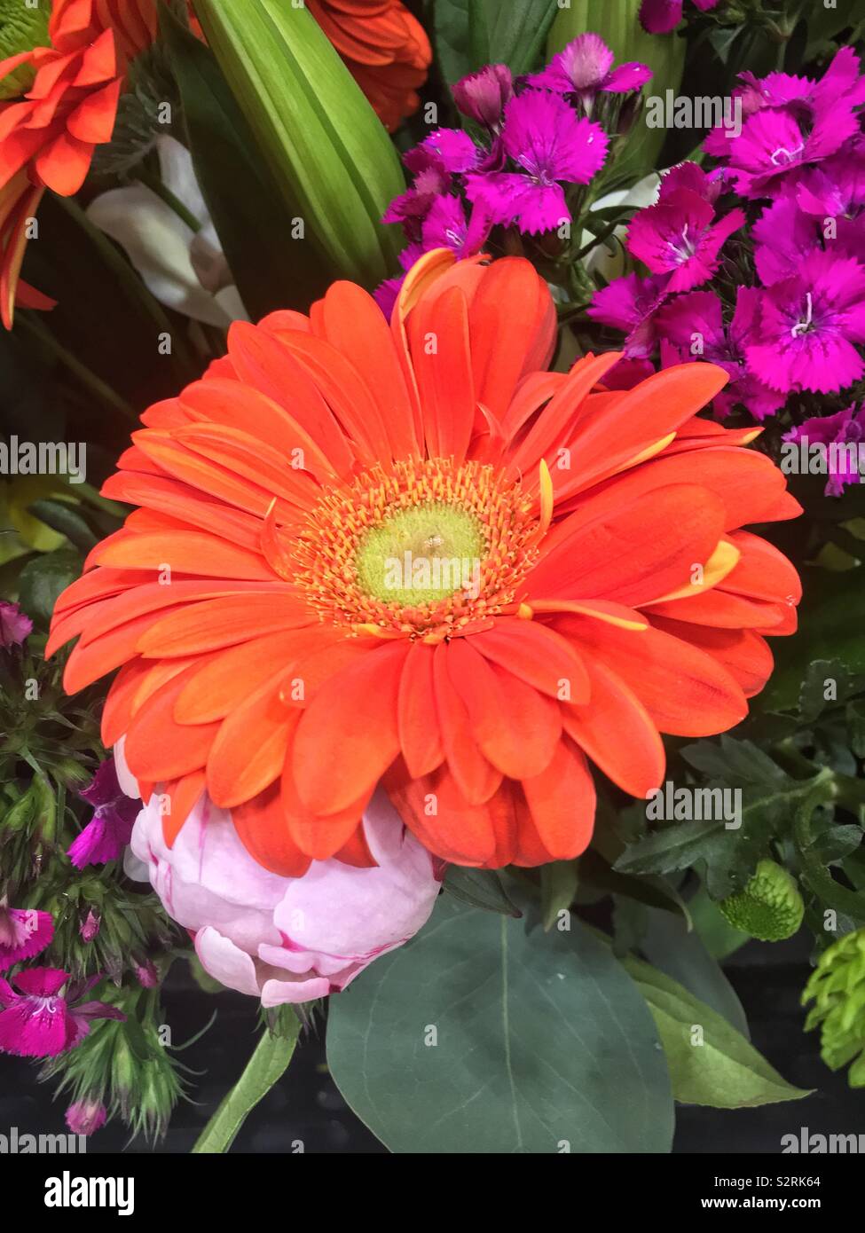 Beau bouquet de fleurs fraîches et d'une grande marguerite orange comme une pièce maîtresse. Banque D'Images