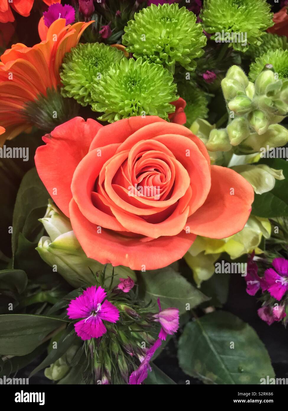 Beau bouquet de fleurs fraîches et d'une orange rose au centre. Banque D'Images