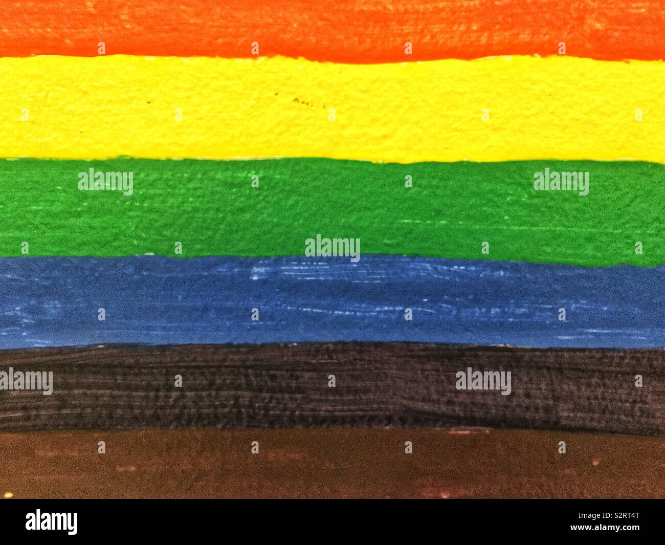 Bel arc-en-ciel peint sur un mur, rouge, jaune, orange, vert, bleu, noir et rayures brunes. Banque D'Images