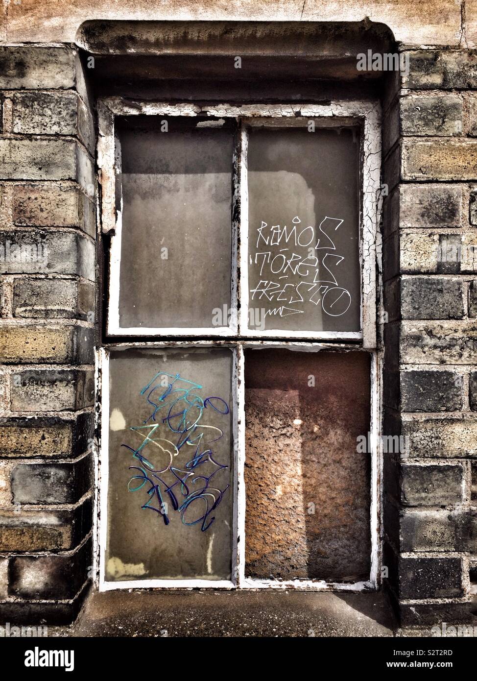 Une vitre cassée couvert de graffitis dans un entrepôt désaffecté à Tottenham, Londres. - Image de stock capturée avec un smartphone