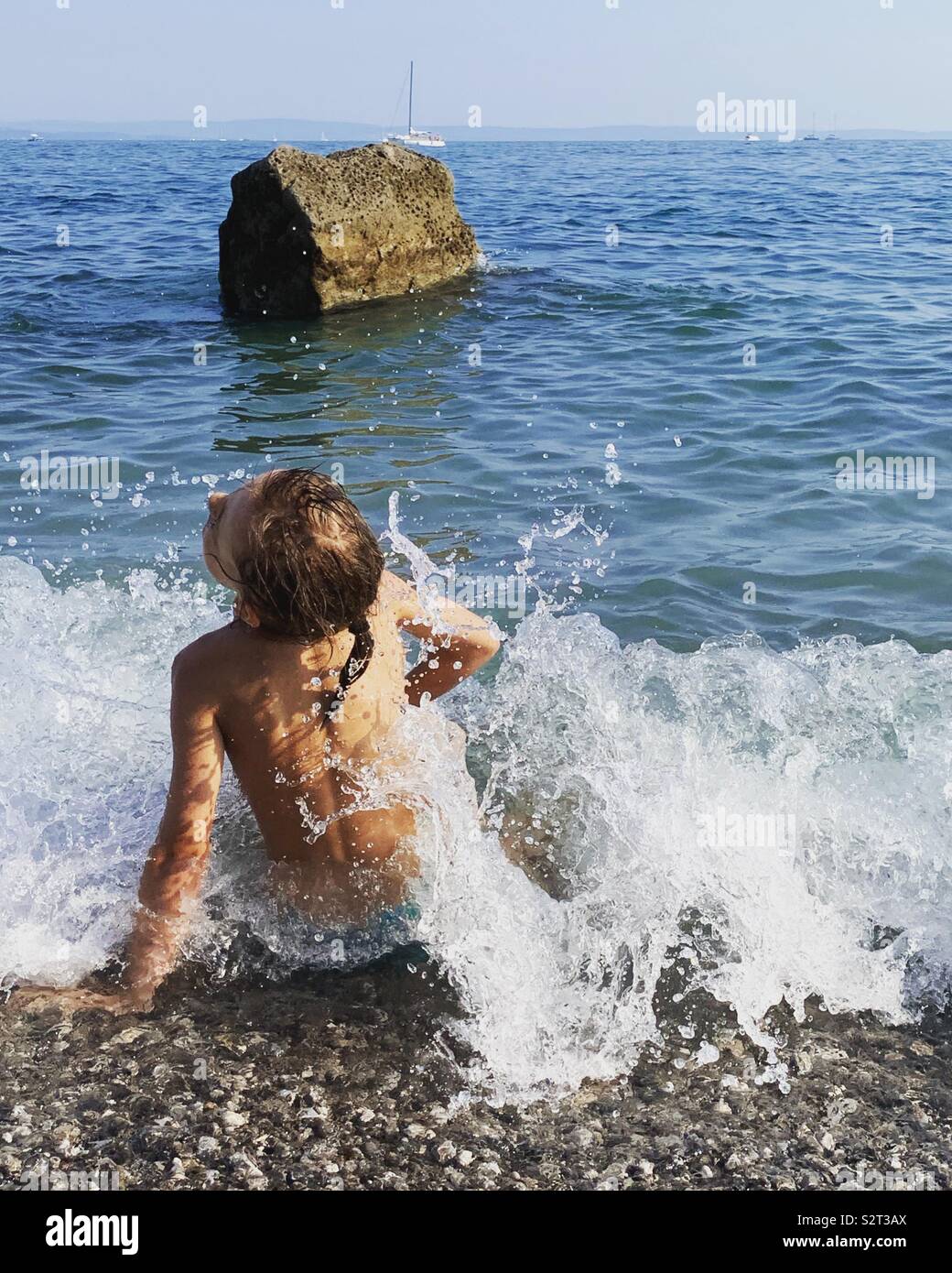 Fille jouant avec les vagues sur la mer. Banque D'Images