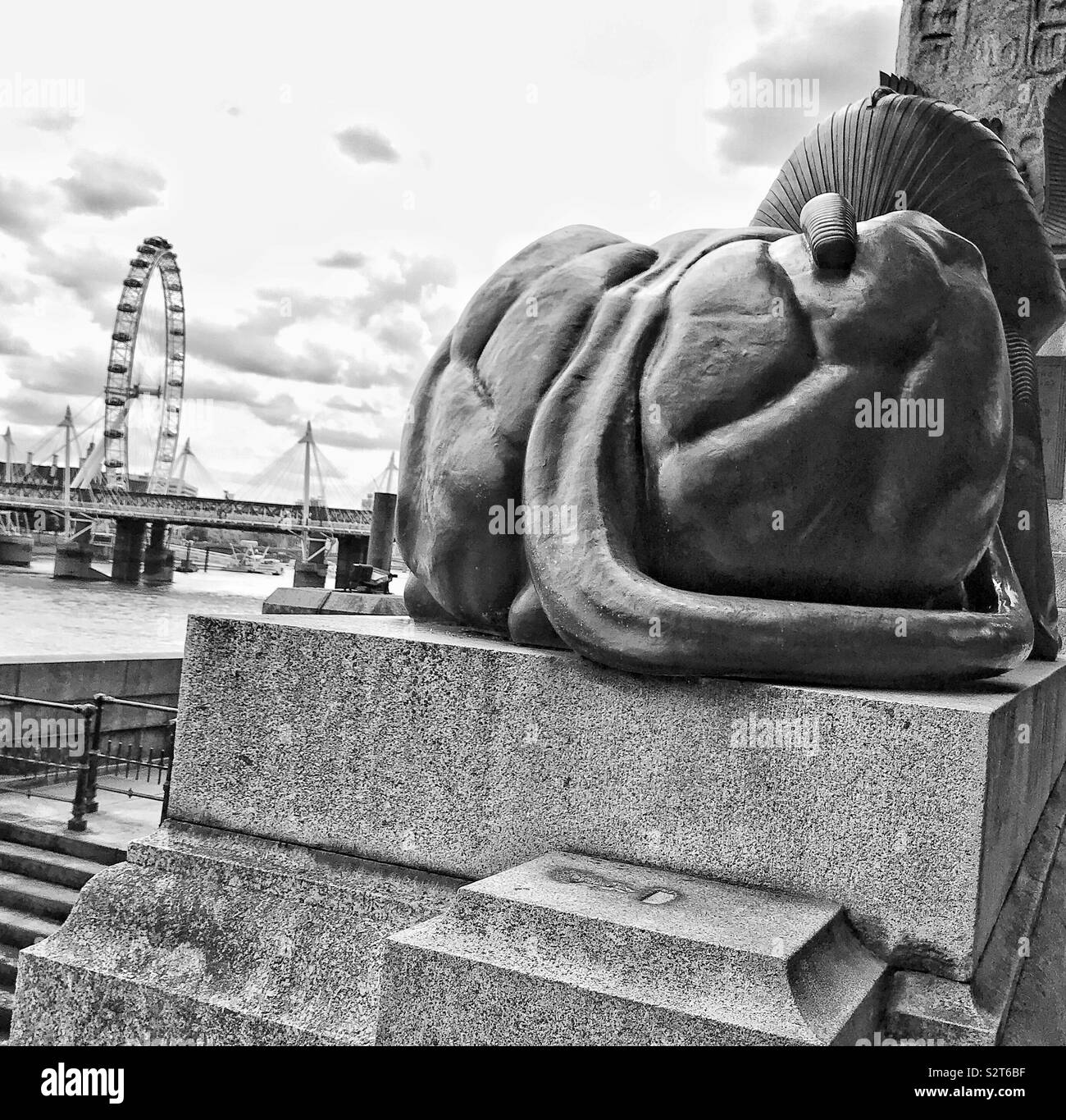 Le London Eye, vue de la mauvaise fin de l'un des sphinx sur le Victoria Embankment. Banque D'Images