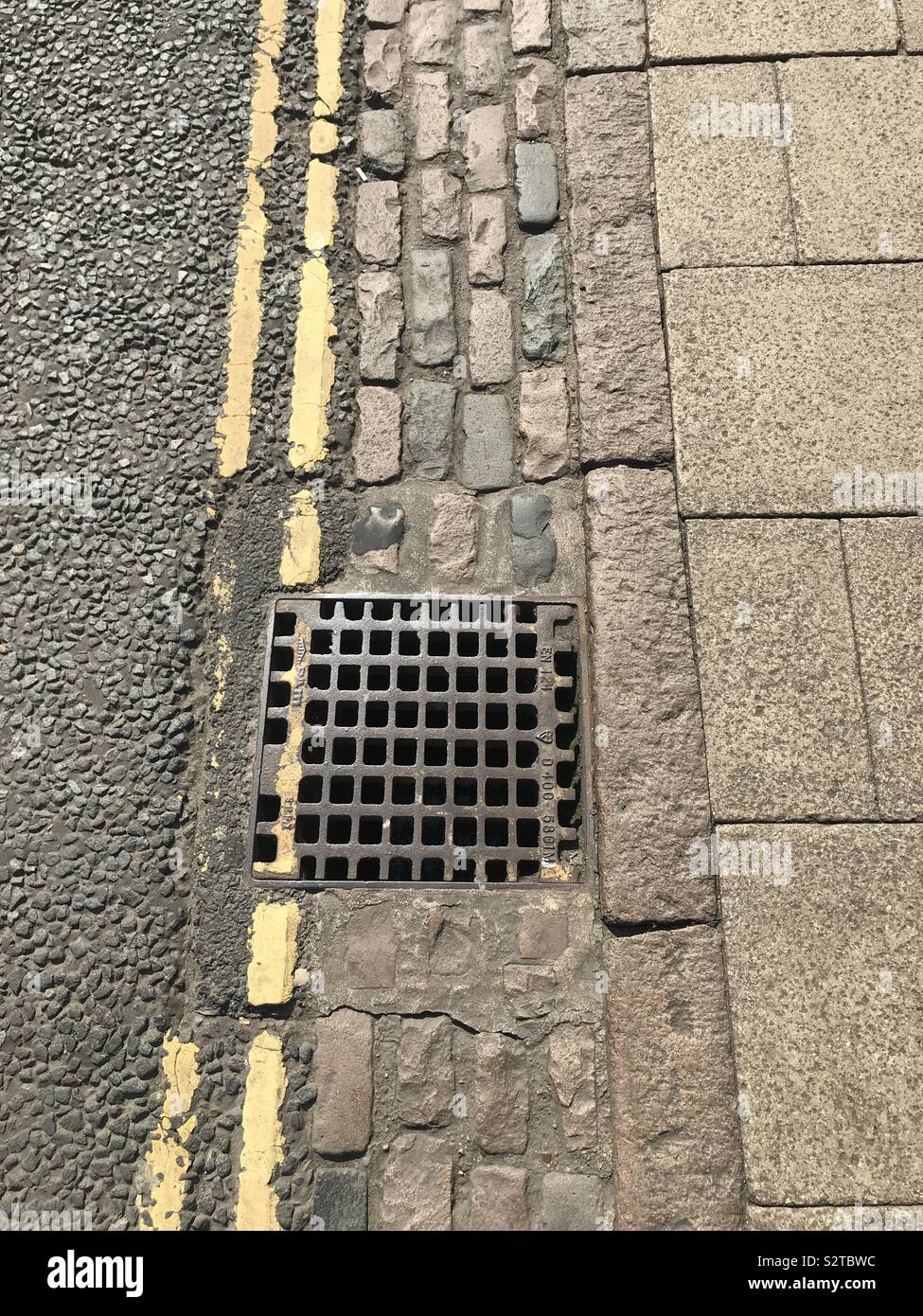 Une partie de la route avec double ligne jaune et lieu de vidange d'eau. - Image de stock capturée avec un smartphone
