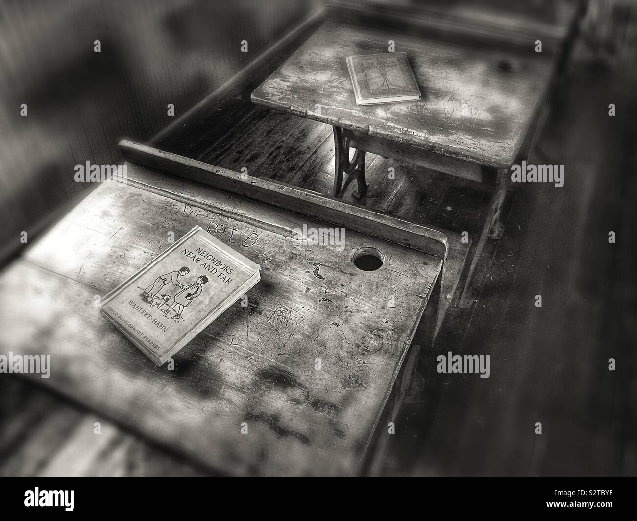 Pupitres étudiants dans une ancienne salle de classe en noir et blanc Banque D'Images