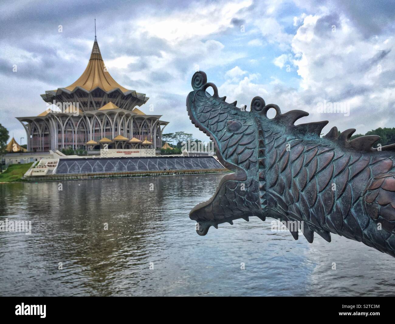 L'un d'une paire de canons conçu comme dragons chinois surplombant la rivière Sarawak, avec l'Édifice de l'Assemblée législative de l'État, front de mer de Kuching, Sarawak, Malaisie - Image de stock capturée avec un smartphone