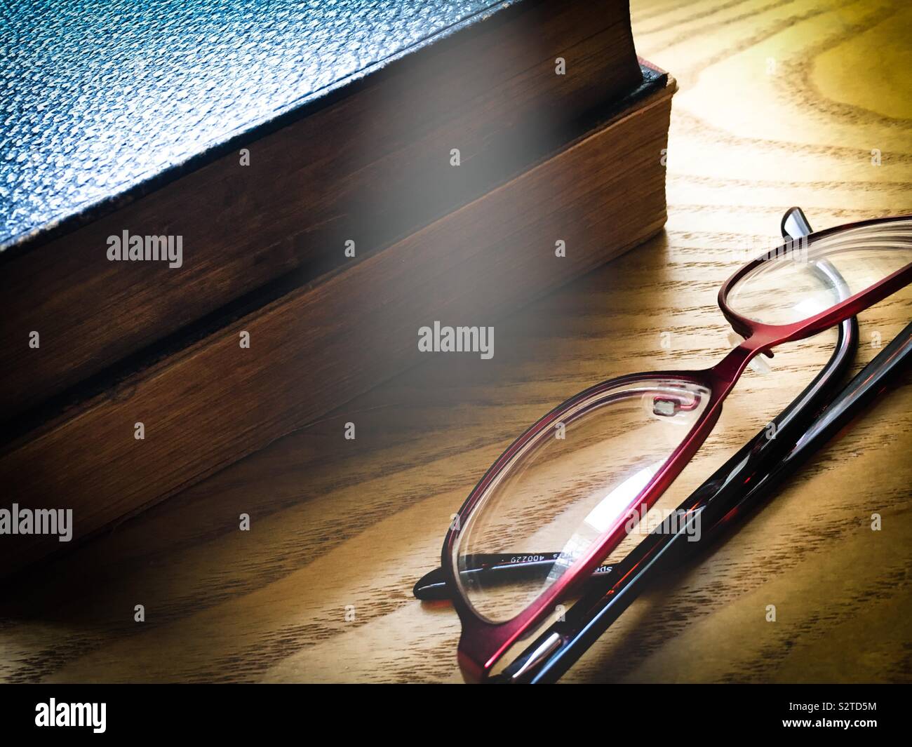 Deux vieux vintage books et une paire de lunettes de lecture posés sur une table en bois Banque D'Images