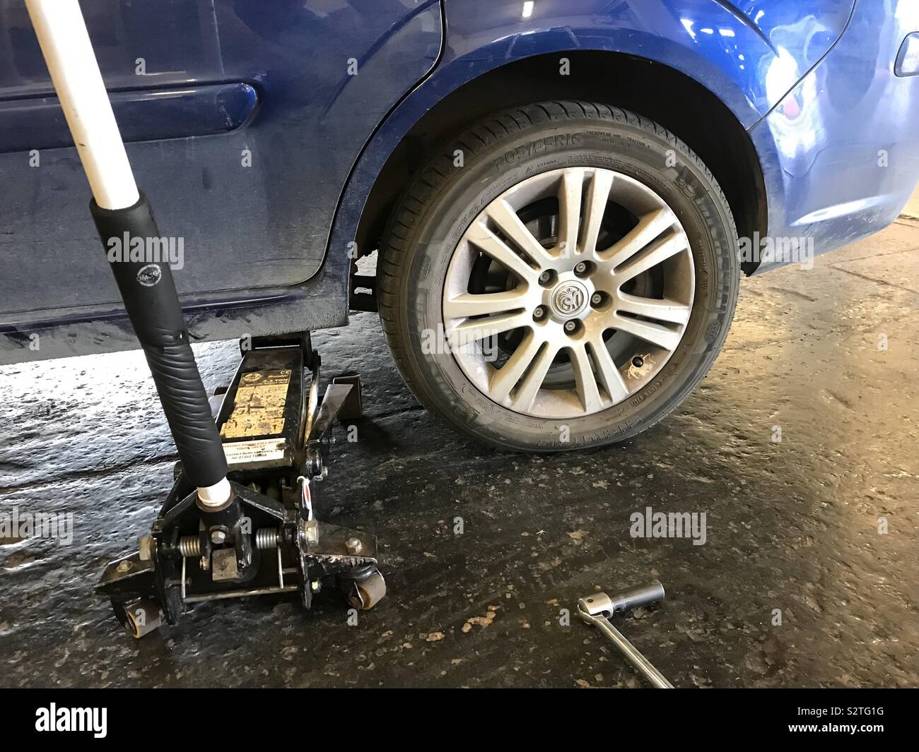 Une voiture sur un cric de voiture pour réparer une crevaison. - Image de stock capturée avec un smartphone