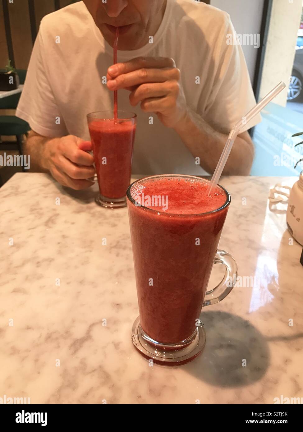 L'homme de boire un smoothie aux framboises - Image de stock capturée avec un smartphone