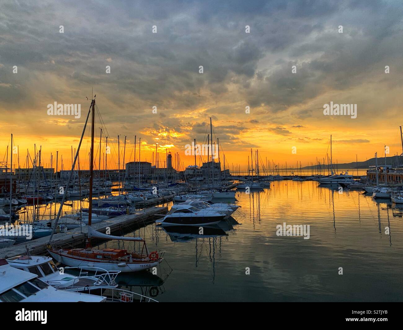 Coucher du soleil sur le port de plaisance et le phare. Trieste, Italie. - Image de stock capturée avec un smartphone