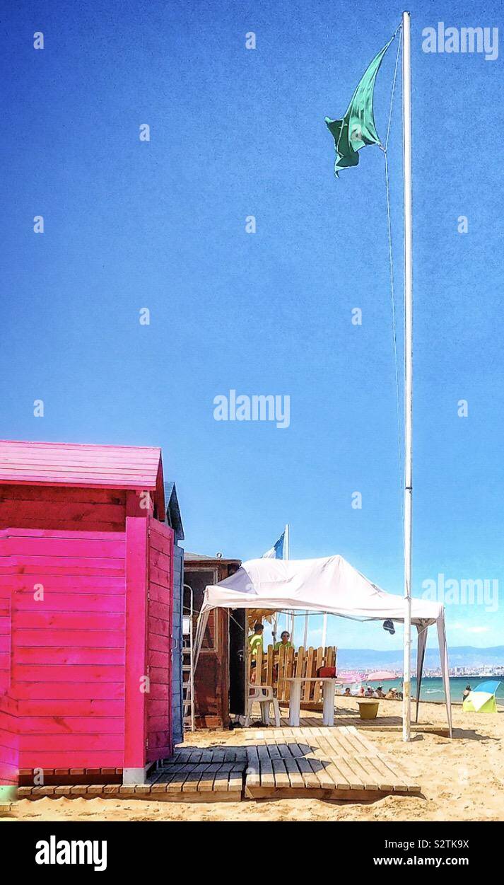 Un drapeau vert est relevé de notifier les baigneurs que les conditions sont réunies pour nager dans la mer. La photo montre un ciel bleu et un soleil brillant Banque D'Images