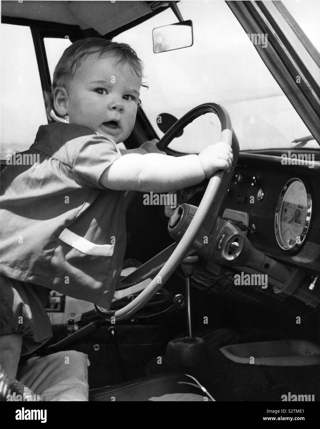 Bebe Maintenant Le Volant De Voiture Au Debut Des Annees 1960 Photo Stock Alamy