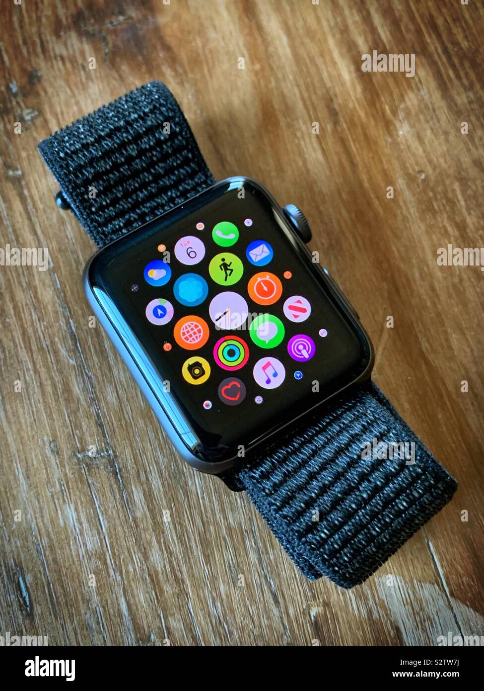 Jeu sur l'écran d'accueil avec des tuiles apps. Bracelet noir sur table en bois Banque D'Images