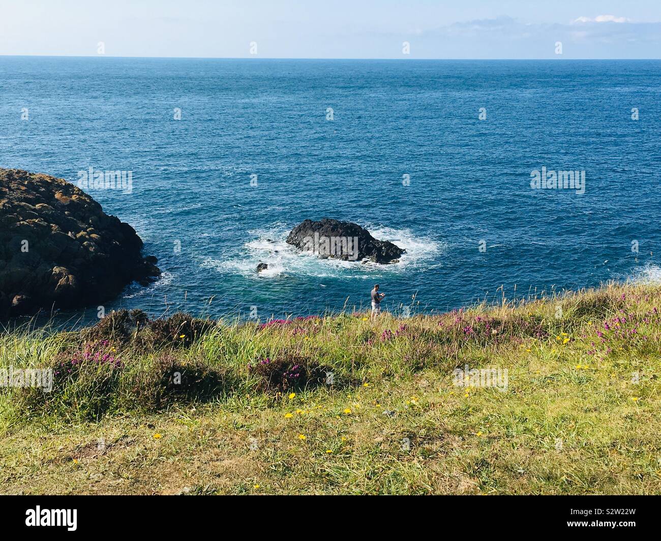 L'homme de prendre des photographies au large de la magnifique côte ouest de Pembrokeshire Wales, UK. Banque D'Images