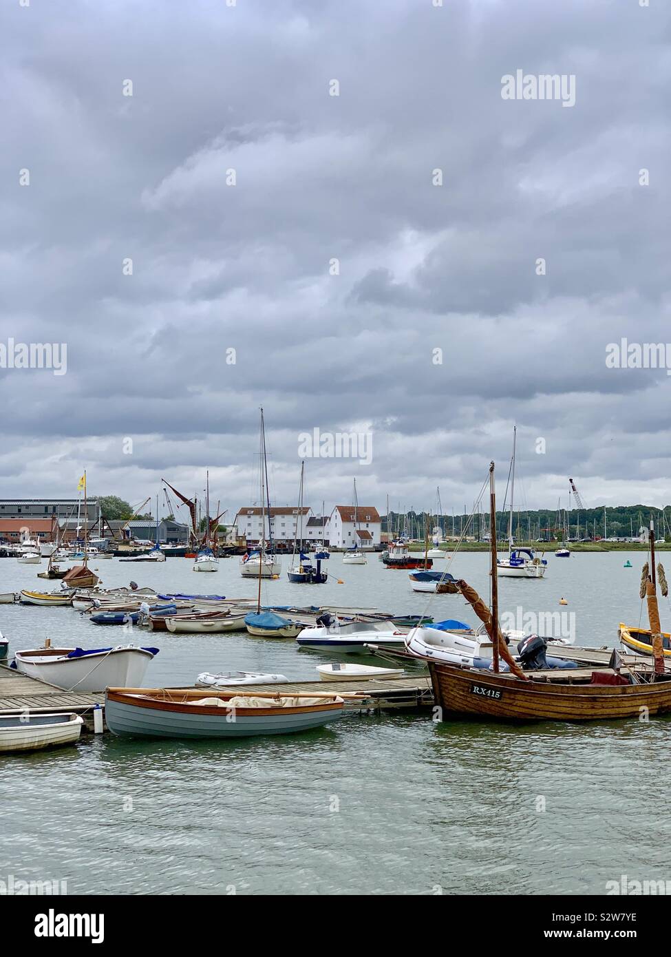 Woodbridge, Suffolk, UK - 16 août 2019 : bateaux amarrés sur la rivière Deben avec le moulin à marée au loin. Banque D'Images