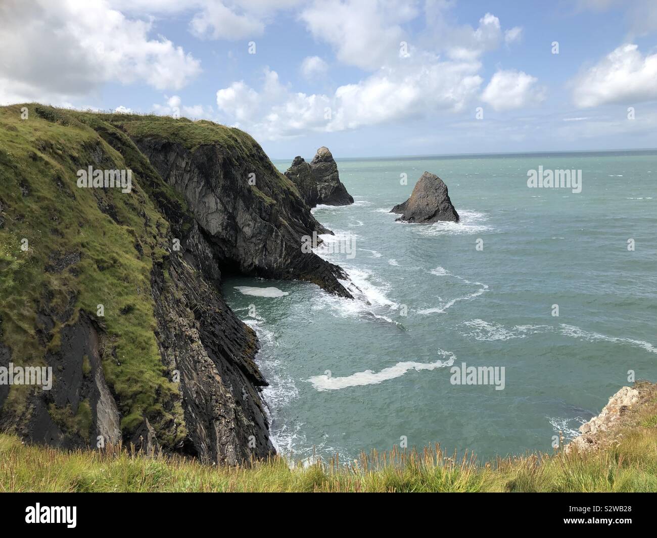 Beau paysage et les falaises côtières avec des piles le long du chemin de la côte du Pembrokeshire, près de la Baie d'Ceibwr. - Image de stock capturée avec un smartphone
