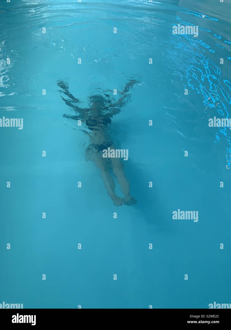 Femme sous l'eau dans une piscine. Banque D'Images
