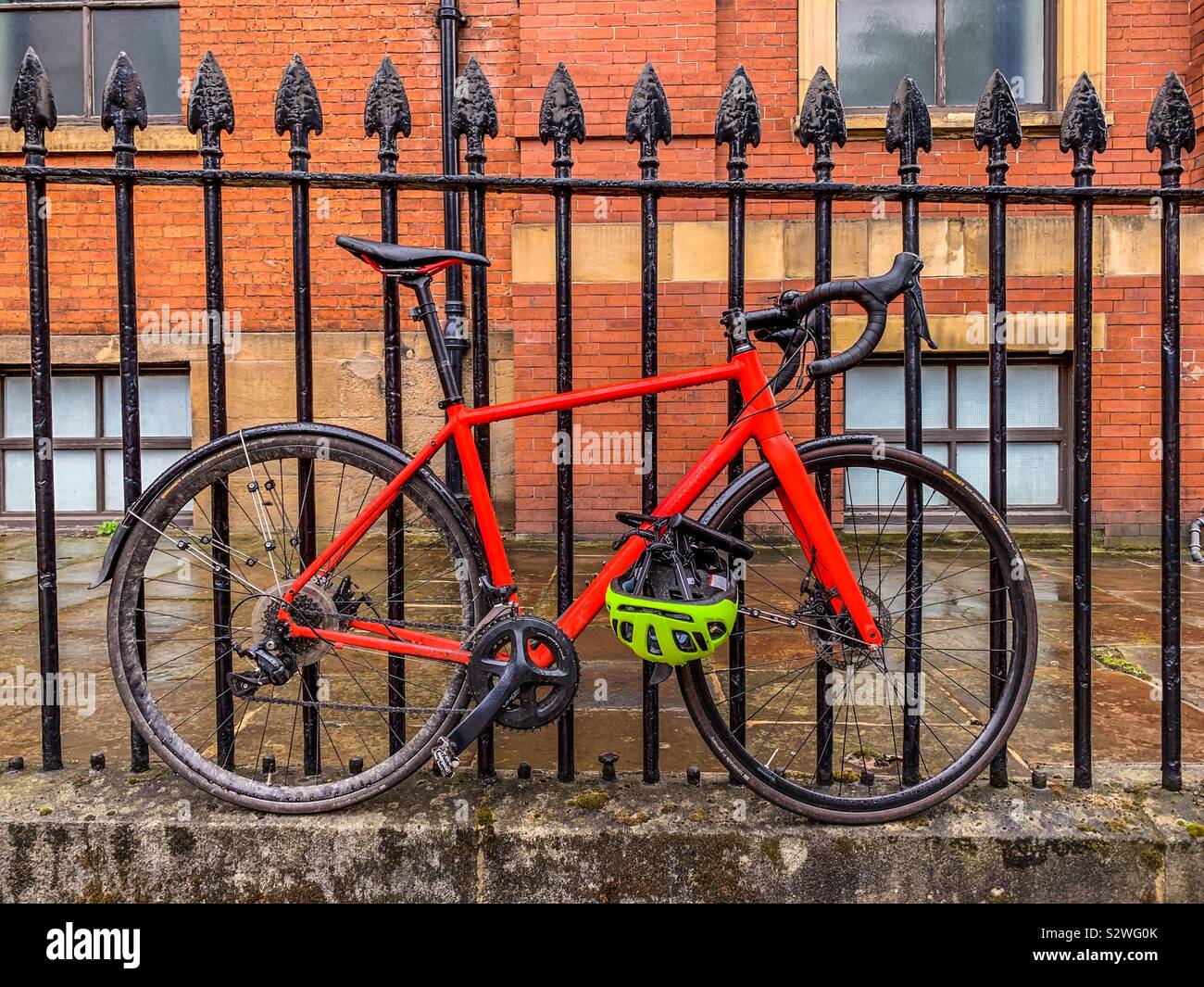 Pousser le vélo enchaîné à fence Banque D'Images