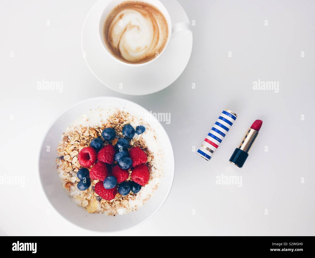 Céréales Petit-déjeuner sain avec des framboises, bleuets, café et le rouge à lèvres rouge sur le côté Banque D'Images