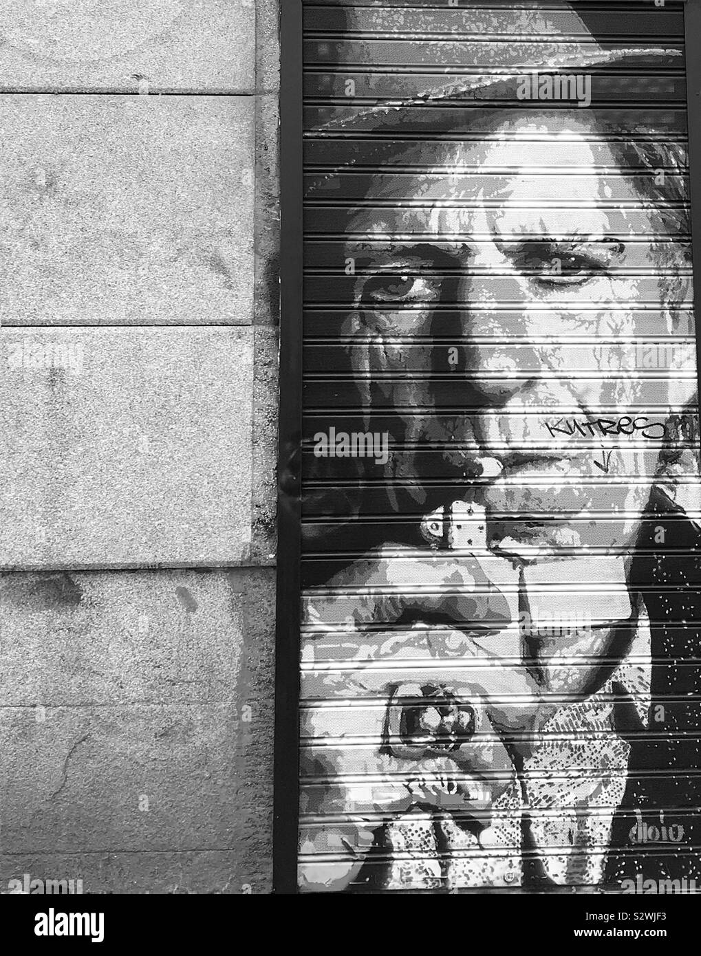 L'art de l'obturateur d'une boutique dans le quartier branché de Malasaña, Madrid fidèlement rock legend Keith Richard des Rolling Stones d'allumer une cigarette. Banque D'Images