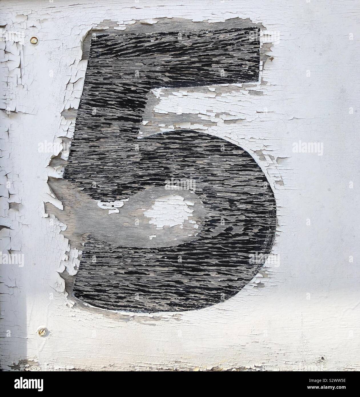 Une altération, fissuré, peint numéro 5 en noir sur un fond blanc. Banque D'Images